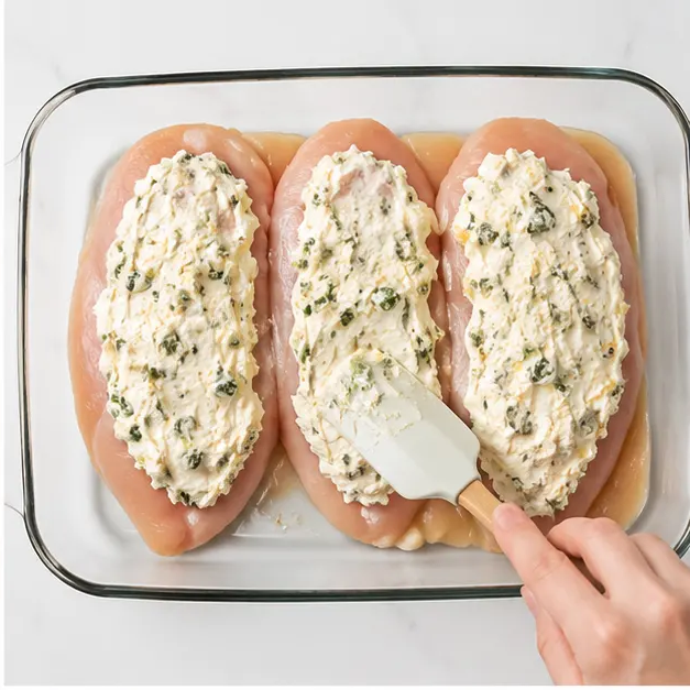 Step 2: Spreading filling over chicken fillets
