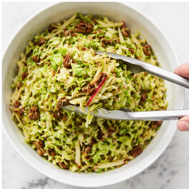 Toss the shaved sprouts, apple matchsticks, and pecans with the dressing