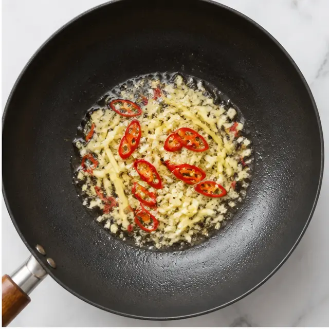 Step 2: Aromatics like garlic and ginger sizzle in the hot oil