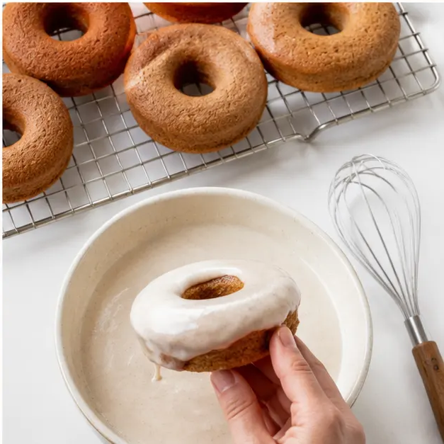 Dipping baked donuts into vanilla cinnamon glaze