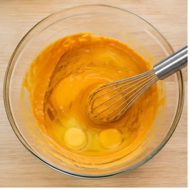Whisking pumpkin puree, eggs, and oil until silky smooth