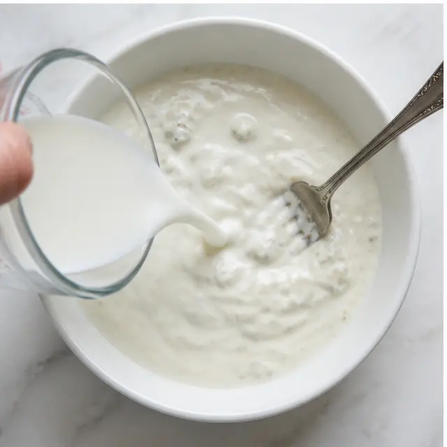 Step 3: Slowly pour milk into the dressing while stirring to thin it