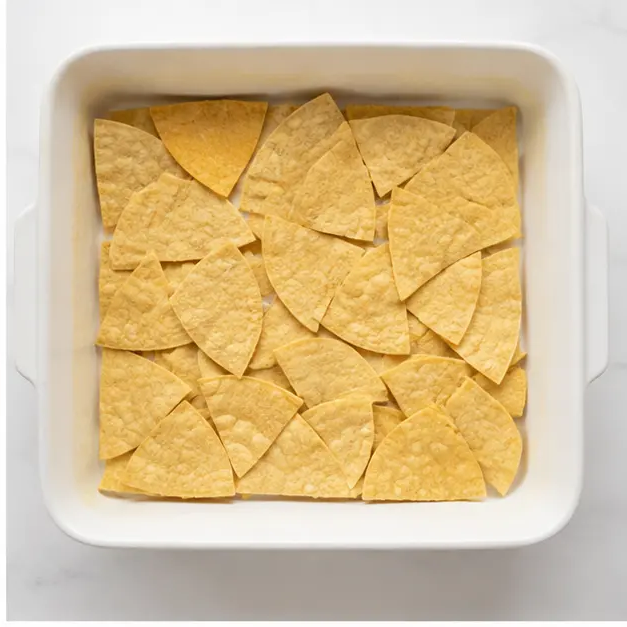 Step 2: Layering corn tortilla quarters in the casserole dish