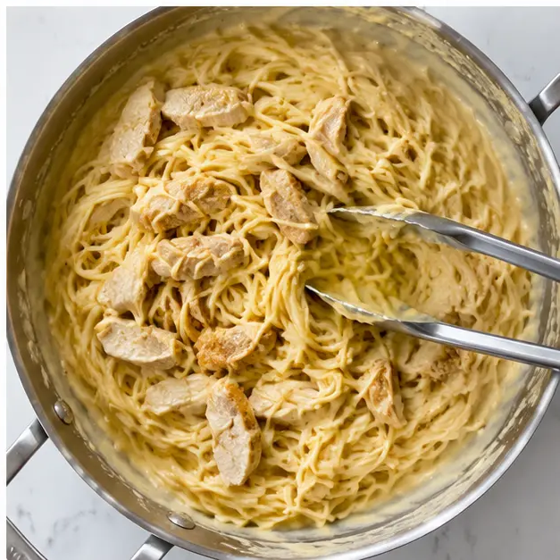 Step 4: Tossing spaghetti and chicken into the creamy cheese sauce