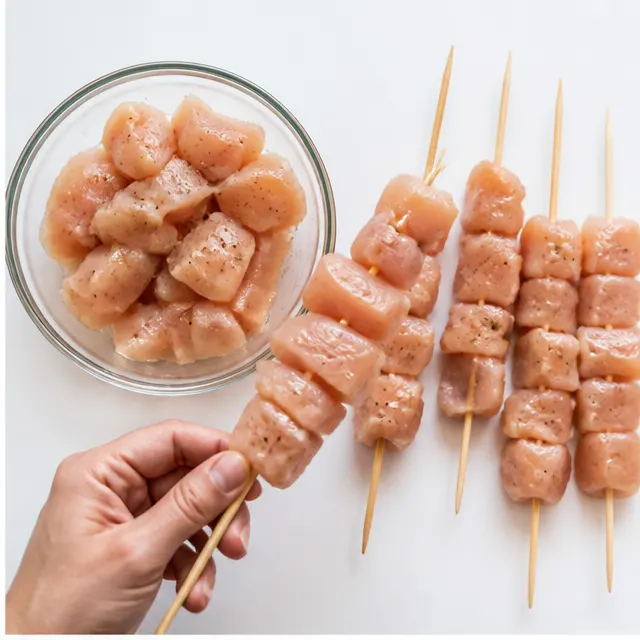Step 2: Thread the raw chicken cubes onto soaked wooden skewers, leaving space between each cube