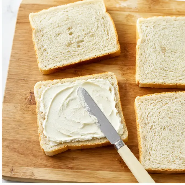 Step 2: Spread cream cheese or butter on soft white bread slices