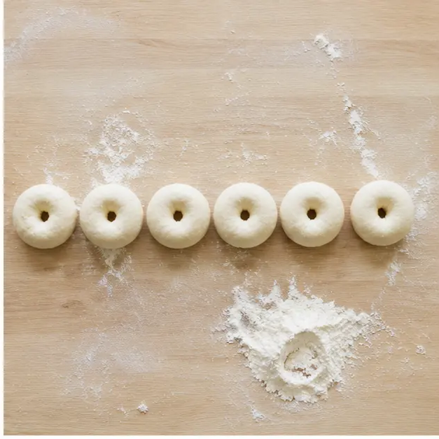 Shaping dough balls with a hole poked through the center of each bite