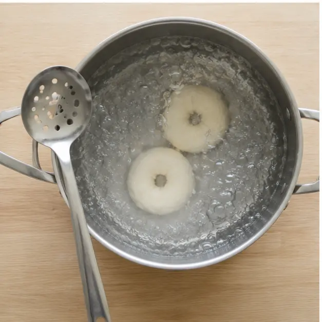 Boiling shaped bagel bites in rolling water for one minute per side