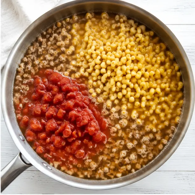 Step 2: Adding uncooked macaroni, tomatoes, and broth