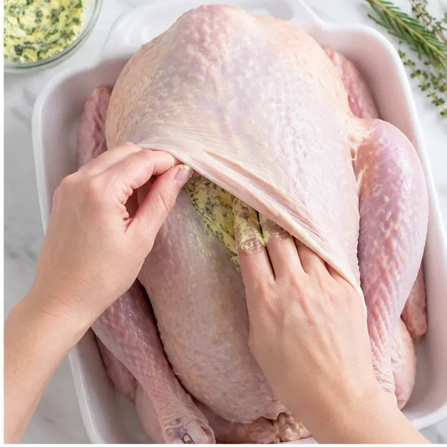 Loosen the skin of the turkey roast and apply the herb butter underneath