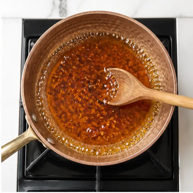 Step 2: Watching for tiny bubbles at the edges of the pan as the chili-infused honey heats slowly