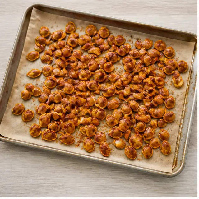 Roasting spiced pumpkin seeds on a baking sheet until golden and caramelized