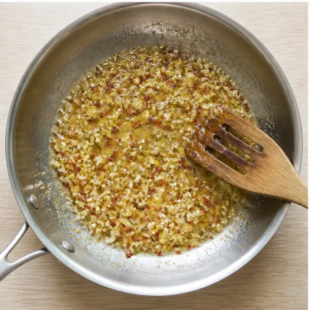Simmering garlic, broth, and lemon into a glossy sauce