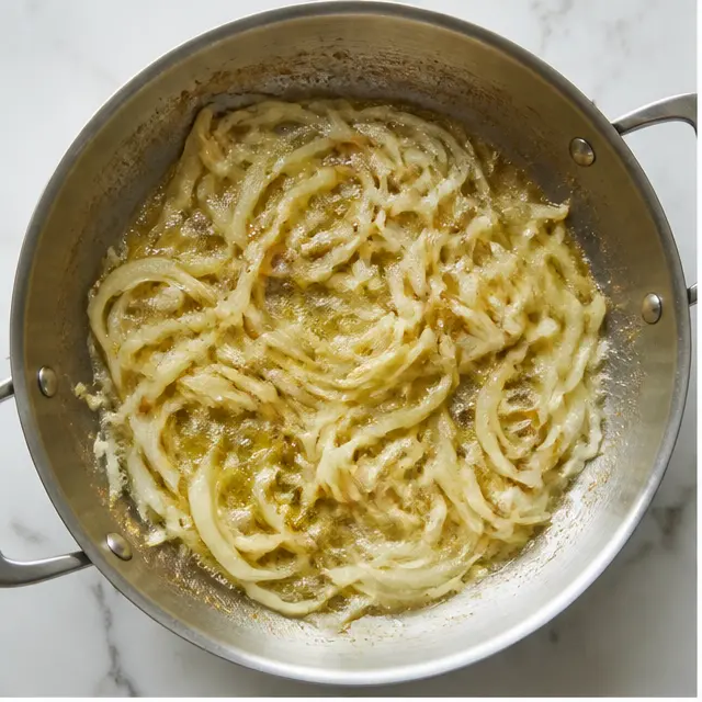 Step 1: Caramelize the sliced yellow onions in butter until soft and deeply browned.