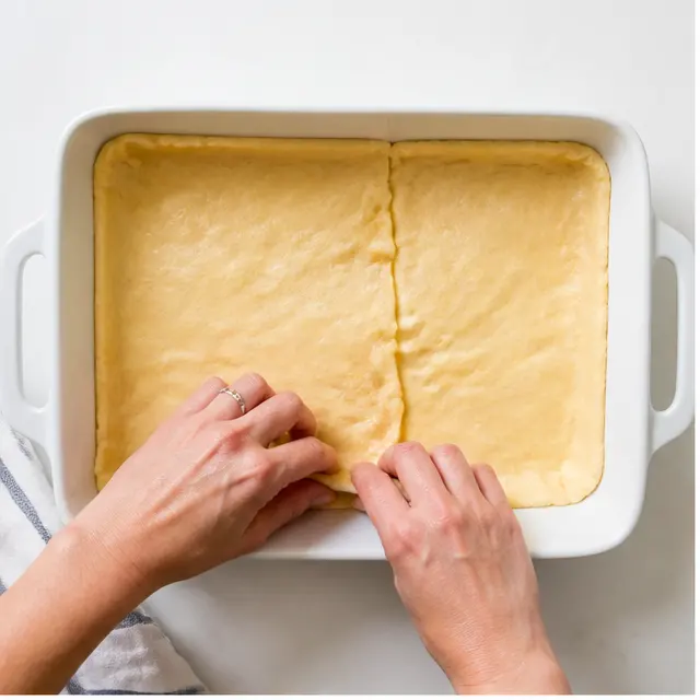 Press crescent dough into the baking dish and par-bake
