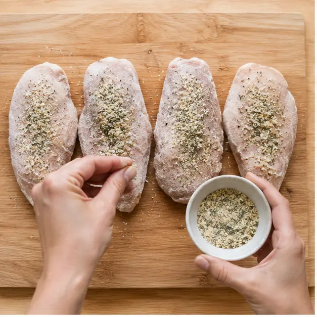 Seasoning frozen chicken fillets with garlic-herb seasoning
