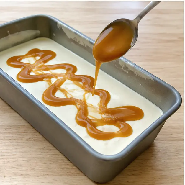 Layer half the ice cream base into the chilled loaf pan and drizzle thick caramel sauce in ribbons