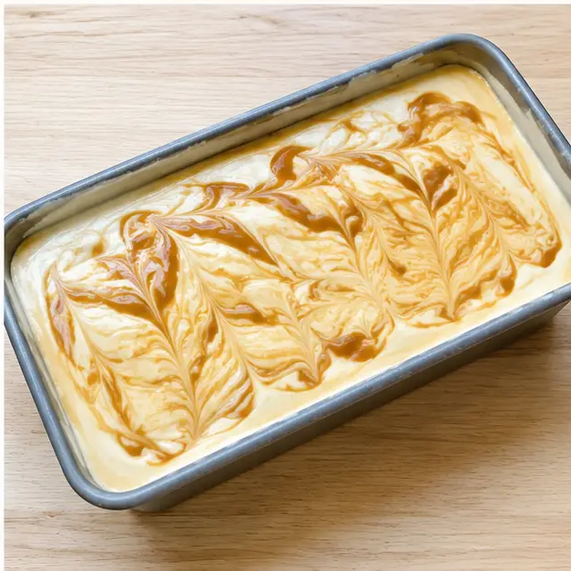 Swirl the caramel through the pan with a knife in a few lazy zigzags, then freeze until firm