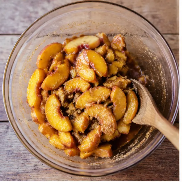 Macerate ripe peach slices with brown sugar, spices, and lemon juice until juicy