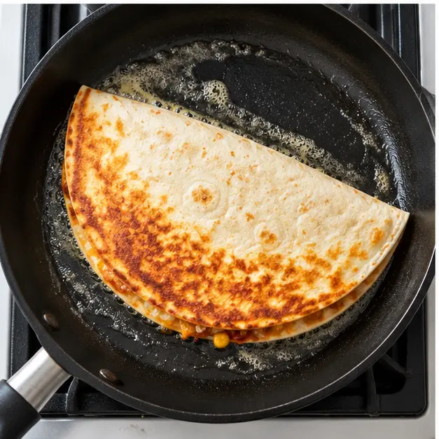Step 3: Cook the quesadilla in a large skillet with olive oil or butter over medium-low heat until the underside is deeply golden, then flip once